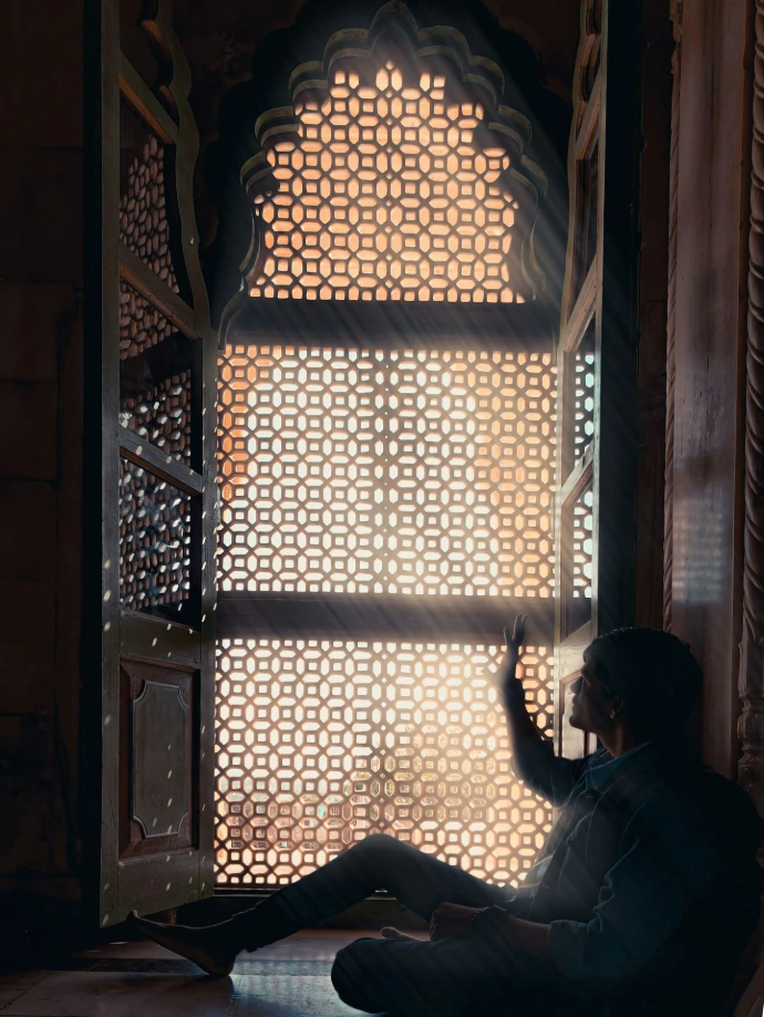 a man sitting on a chair looking out a window
